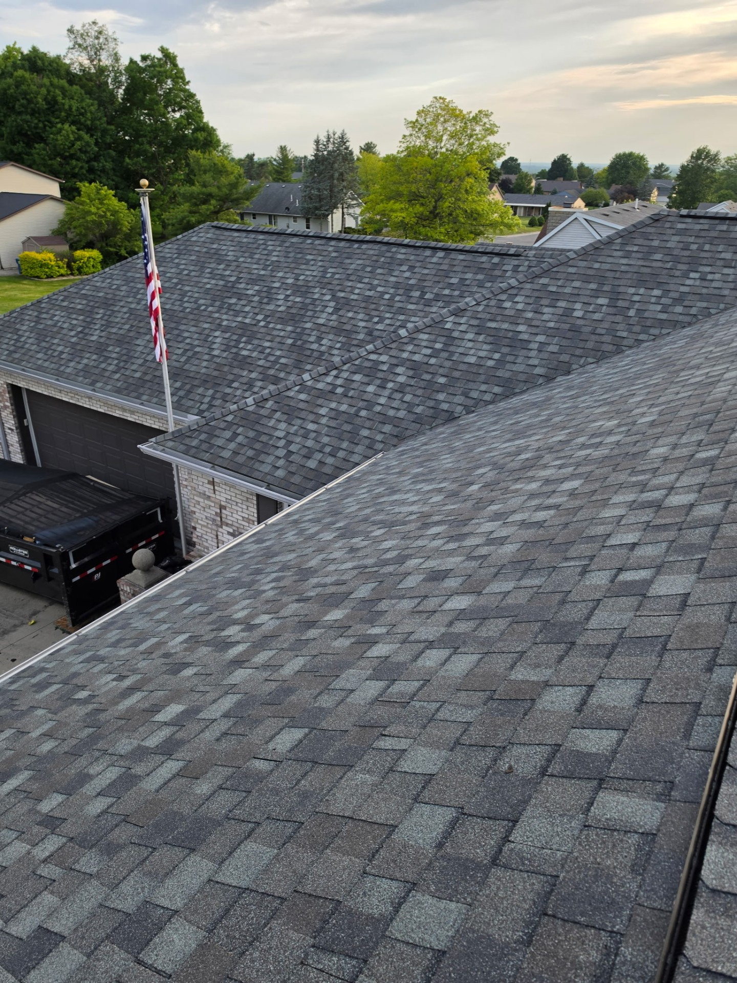 Aerial of completed architectural shingle roof with American flag over Whispering Pines home — Bellefontaine, Ohio