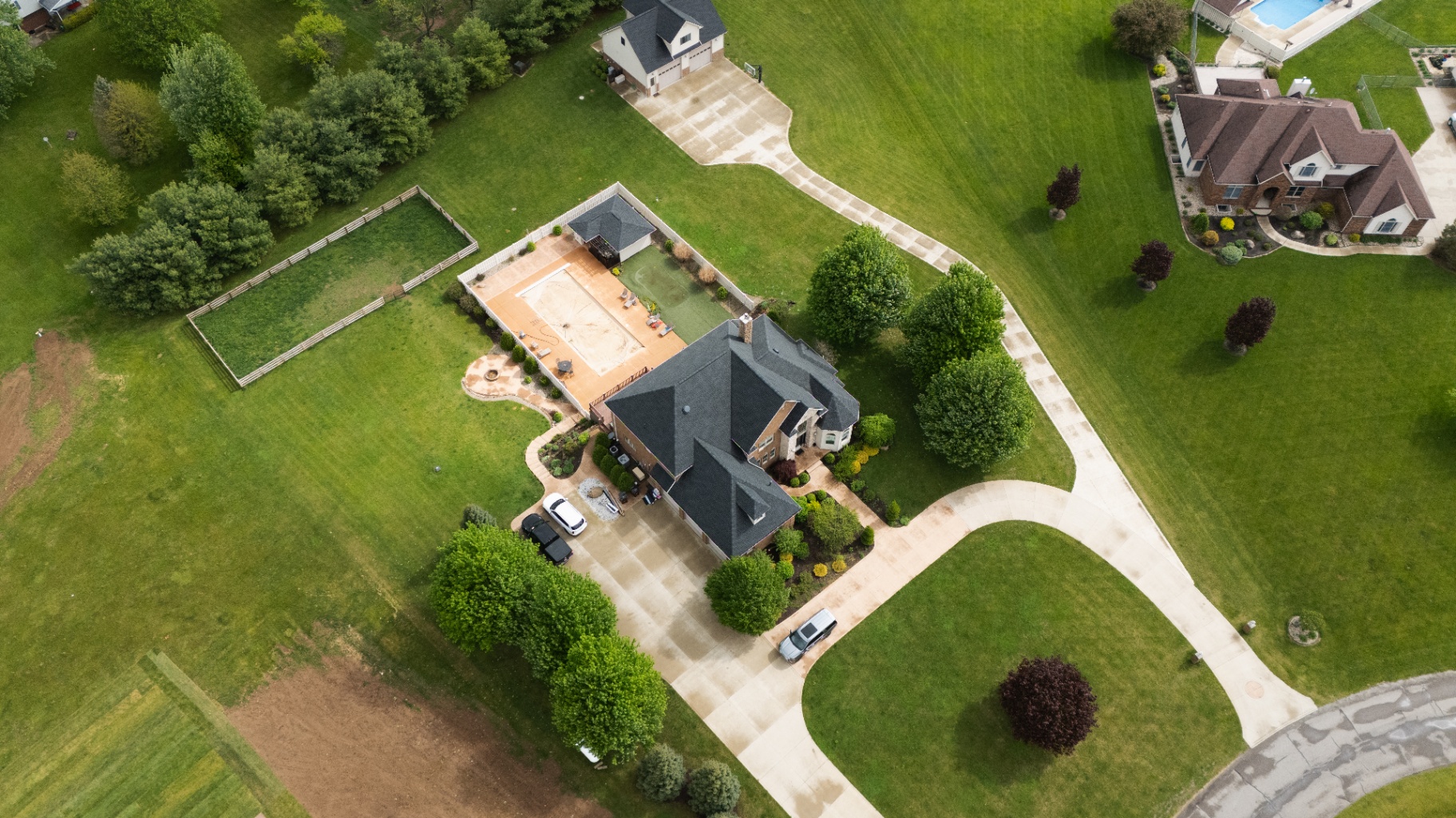 Pulled-back aerial showing the home in the context of the Whispering Pines neighborhood — Bellefontaine, Ohio GAF certified residential roof replacement