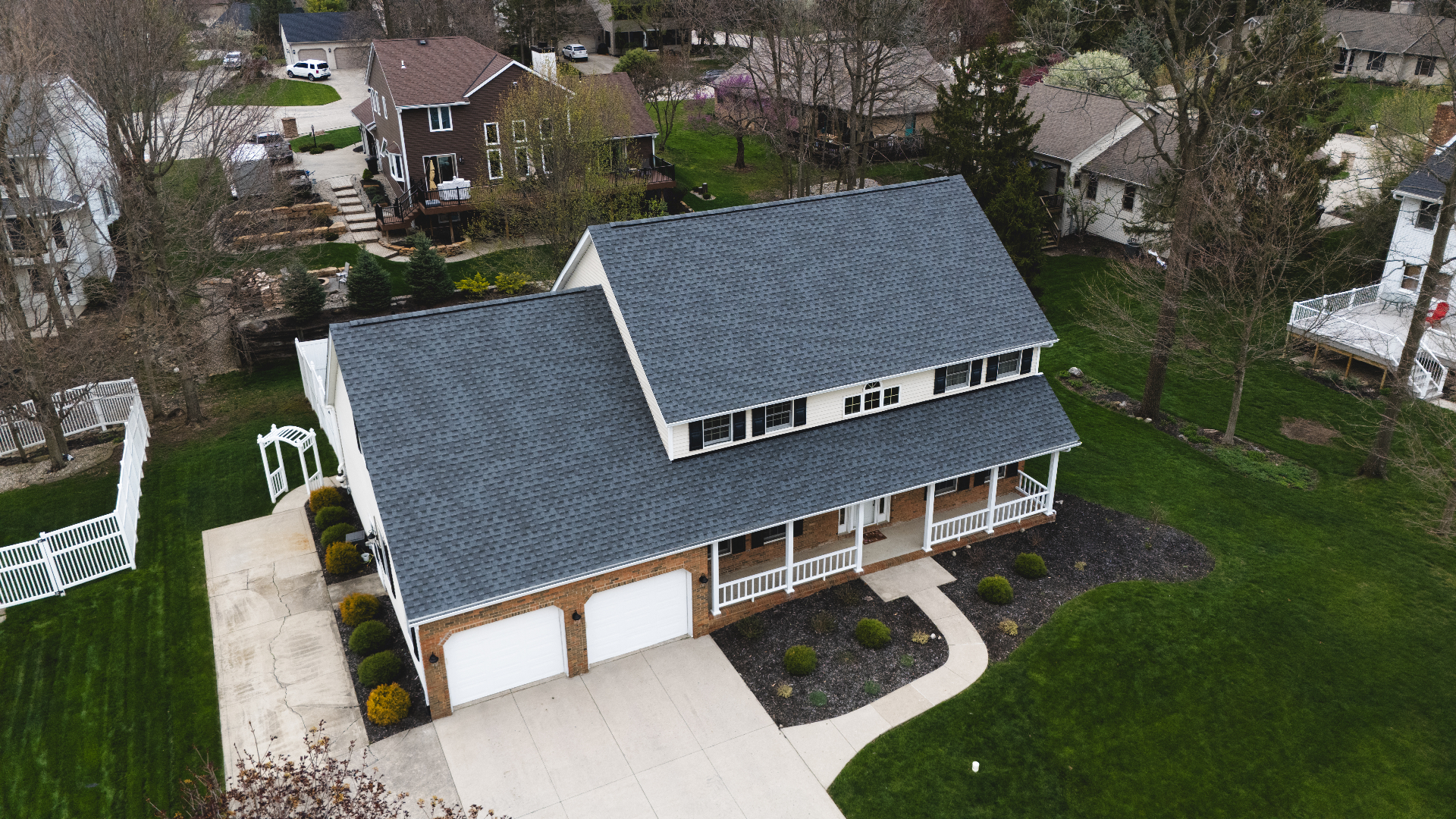 Aerial view of completed charcoal GAF Timberline HDZ shingle roof on a second neighborhood home — Whispering Pines, Bellefontaine, Ohio GAF certified roof replacement by Peak One Restorations
